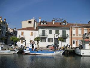 格拉多Villa Eleonora的一群船停靠在运河上,有建筑物