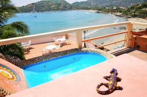 锡瓦塔塔内霍卡萨日月酒店的一个带游泳池和海滩的阳台