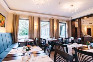 鲁尔河畔米尔海姆HOTEL KOCKS am Mühlenberg的餐厅设有桌椅和窗户。