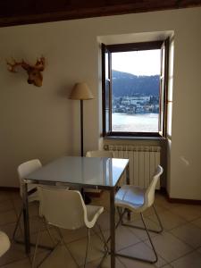奥尔塔圣朱利奥Casa Vacanza Isola的一间带桌椅和窗户的用餐室