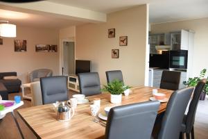 梅斯Grand Appartement Vue Cathédrale的用餐室以及带木桌和椅子的客厅。
