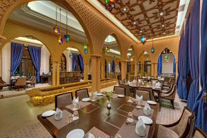 加尔各答Ibiza The Fern Resort & Spa, Kolkata的一间在房间内配有桌椅的餐厅