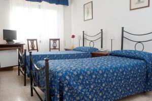 罗马安蒂科亚葵多托酒店的配有蓝色棉被的客房内的两张床
