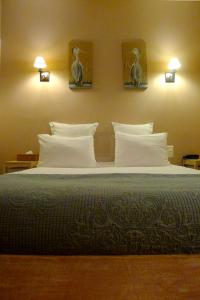 桑特Cit'Hotel des Messageries的卧室配有一张大床,墙上有枕头和鸟