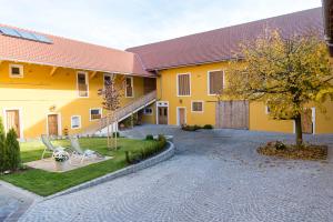 海格-安豪斯奥克奥勒霍夫酒店的庭院里设有两把草坪椅的黄色房子