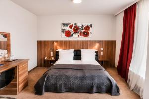蒂米什瓦拉总统酒店 的一间卧室配有一张大床和红色窗帘