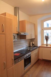 蒙绍Zum alten Landrat的厨房配有木制橱柜和炉灶烤箱。