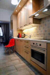 雅典Gazi Boutique Apartment 2的厨房配有炉灶和红色椅子