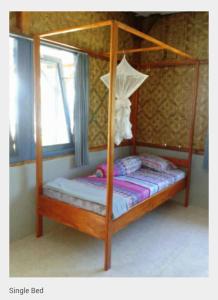 Keli乐克乐姆波旅馆的一间卧室设有天蓬床和窗户。