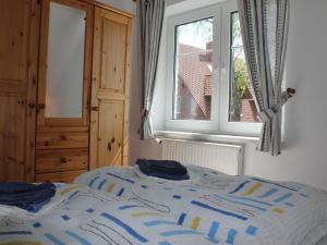 青斯特Cozy Apartment in Zingst Germany with Garden的一间卧室配有一张带窗户和蓝色床单的床
