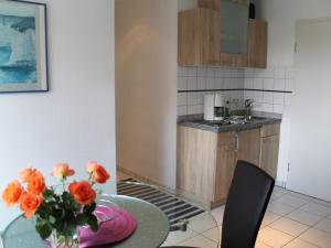 青斯特Cozy Apartment in Zingst Germany with Garden的厨房配有桌子和橘子花花瓶