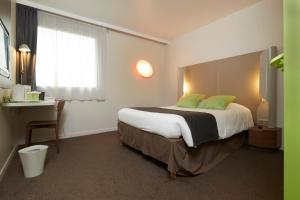 南特钟楼南特中央圣雅克酒店的一间卧室配有一张带绿色枕头的大床