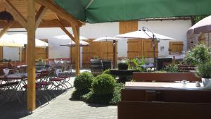 航旺兰德加斯特霍夫&怀尔特兰德酒店的一间带桌椅和遮阳伞的餐厅