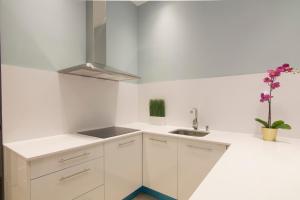 马德里Luxury Alonso Martinez Madrid的白色的厨房配有白色橱柜和水槽