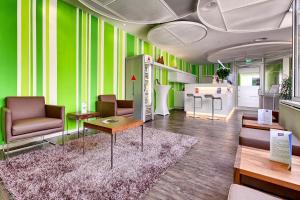 斯图加特阿提莫斯图加特*** S酒店的一间设有绿色墙壁、椅子和桌子的客房