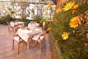 罗马卡梅尔酒店的一个带桌椅和鲜花的温室