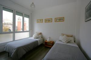 巴塞罗那埃斯帕广场豪华公寓的一间卧室设有两张床和窗户。
