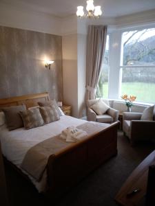 Bassenthwaite Lake里可宾馆的卧室配有床、椅子和窗户。