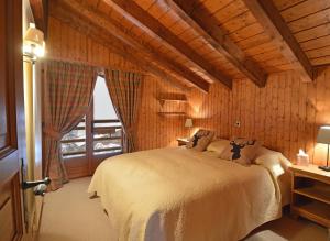 韦尔比耶Combe de l'A 222的卧室配有一张床铺,位于带木墙的房间内