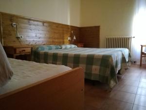 圣洛伦索-德莫鲁尼斯加泰罗尼亚旅馆的酒店客房设有两张床和木墙