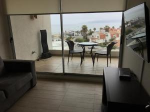 科金博Apartamento en Club Oceano的阳台设有带桌椅的客厅