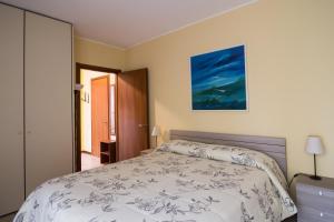 圣多纳托-米拉内塞Cozy Penthouse的卧室配有一张床,墙上挂有绘画作品