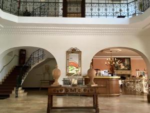 圣让-德吕兹尚塔克高尔夫康体酒店的大堂设有楼梯和一张带花瓶的桌子