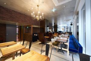 东京东京六本木苏铁草莓酒店的餐厅设有木桌、椅子和吊灯。