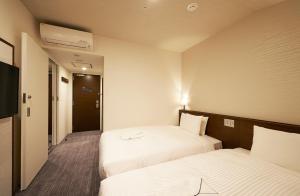 东京东京六本木苏铁草莓酒店的酒店客房设有两张床和电视。