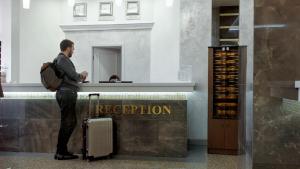 Birobidzhan酒店中央（沃斯托克）的带着行李站在柜台上的人