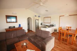 Stokes Bay袋鼠岛海浪野生小屋的客厅配有沙发和桌子