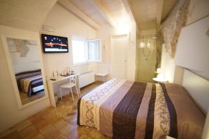 马泰拉贝尔维德勒二号酒店的一间卧室配有一张床、一张书桌和一个窗户。