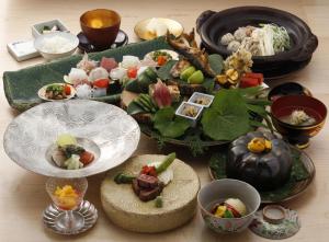 由布市汤布院草庵秋樱日式旅馆的餐桌,盘子上放着食物和碗