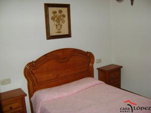 圣马尔廷德尔卡斯塔尼亚尔Casa Lopez的一张带木制床头板和2个床头柜的床