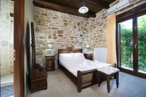 PlátanosVilla Platanos的一间卧室设有一张床和石墙