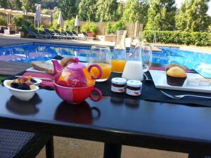 巴古尔Hostalet de Begur - Adults Only的一张桌子,上面放着一盘食物,茶壶和果汁