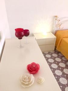 滨海波利尼亚诺Casa Del Parco的两杯酒和一朵玫瑰花在桌子上