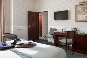 马德里艾普拉杜尔酒店的酒店客房配有一张床、一张书桌和一台电视。