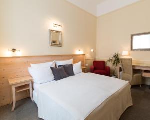 布拉格安盟酒店的卧室配有一张白色大床和一张书桌