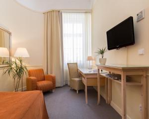 布拉格安盟酒店的酒店的客房,配有书桌和墙上的电视