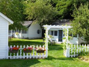 巴港Bar Harbor Cottages & Suites的院子内花卉的白色围栏