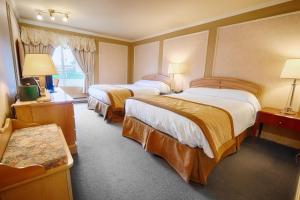 维多利亚维尔Travelodge by Wyndham Victoriaville的酒店客房设有两张床和窗户。