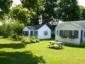 巴港Bar Harbor Cottages & Suites的房屋旁的院子内的野餐桌