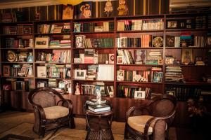 祖格迪迪Casa de Khasia的图书馆配有两把椅子、一张桌子和书籍