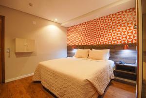 圣保罗碧兹酒店的一间卧室设有一张床和橙色的墙壁
