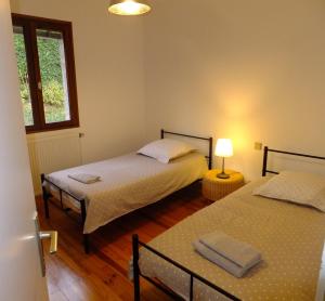 圣艾蒂安克洛斯真提安讷度假屋的一间卧室设有两张床、一个窗口和一盏灯。