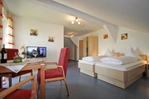 Rotthalmünster费列恩霍夫丽格酒店的酒店客房设有两张床、一张桌子和一张桌子。