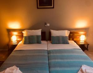 Ribeira GrandeCasa Santa Barbara Deluxe的配有两盏灯的房间的两张床