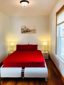 波士顿Boston Lodge and Suites的一间卧室配有一张红色的床和两盏灯