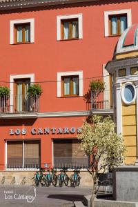 圣玛丽亚港洛斯坎塔洛斯酒店的一座红色的建筑,前面停放着自行车